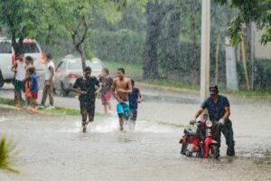 People walking on a flooded street during heavy monsoon rain in India